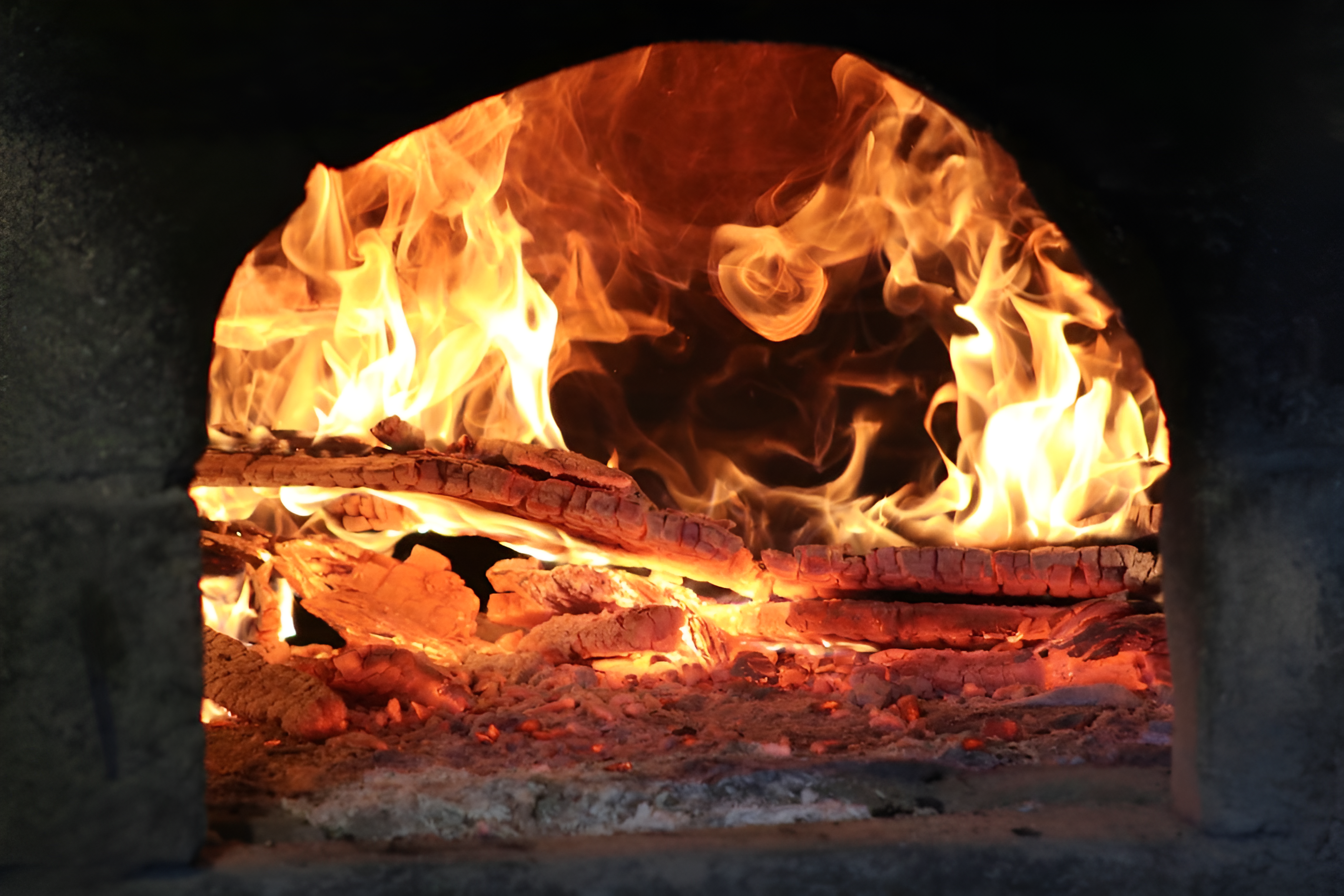 Four à pizza traditionnel en briques avec flammes